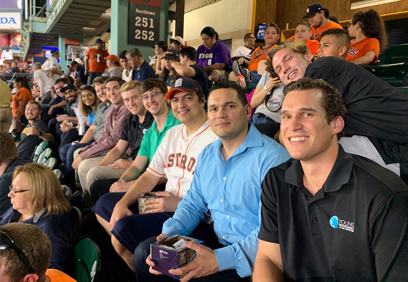 MRE YP employees smiling at camera at baseball game