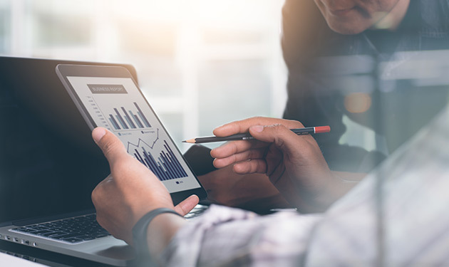 Man looking at a tablet showing graphs and data