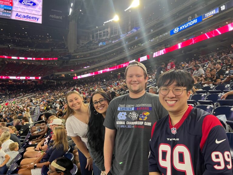 MRE Launchpad employees smiling at camera at a football game